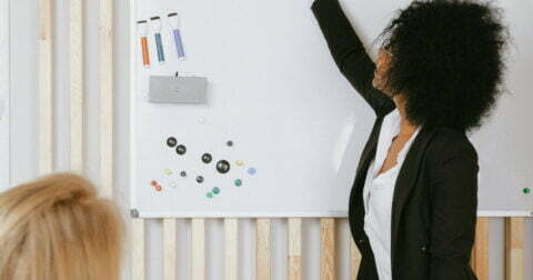 Mulher a escrever em quadro branco