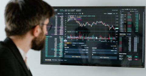 Homem a olhar para monitor com gráficos